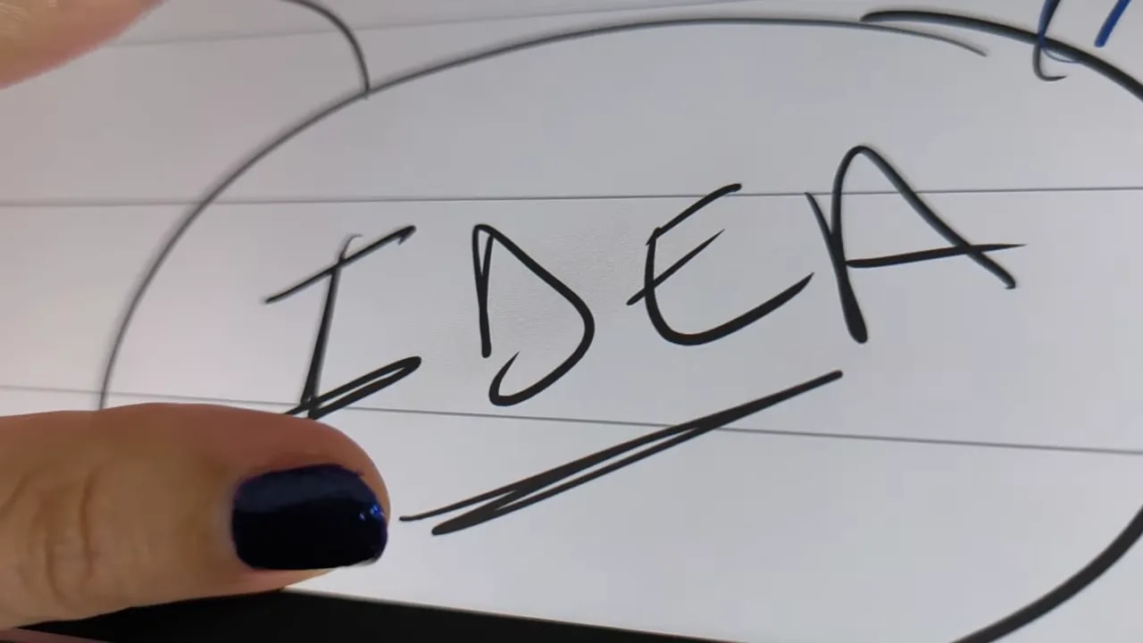 Detalle de la palabra 'IDEA' escrita a mano en la pantalla con textura similar al papel
